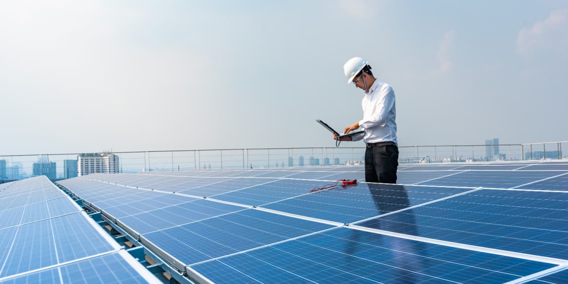 Electrical Engineer using equipment and laptop to measure solar panels