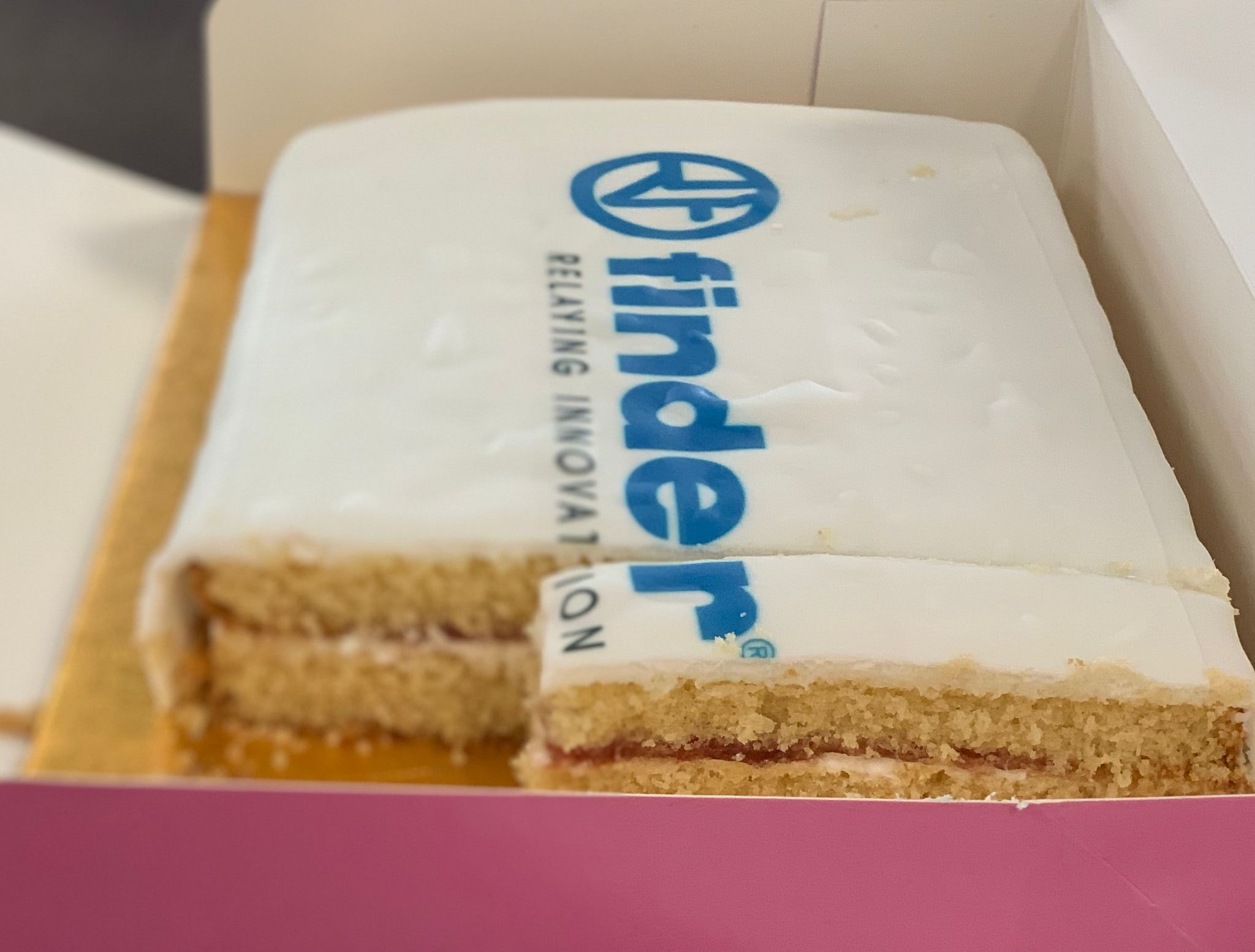 A cut cake with the Finder Logo on the icing. LED Controls is a Finder Official Premium Partner